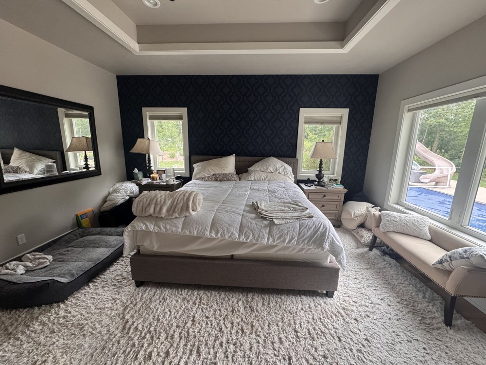 Before: primary bedroom with cluttered nightstands and mismatched lamps